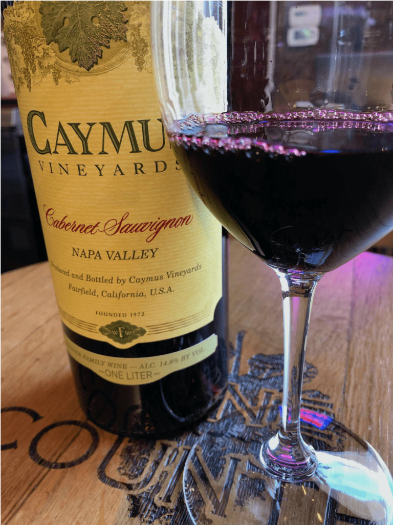 alt="Caymus Napa Valley Cabernet Sauvignon bottle & glass