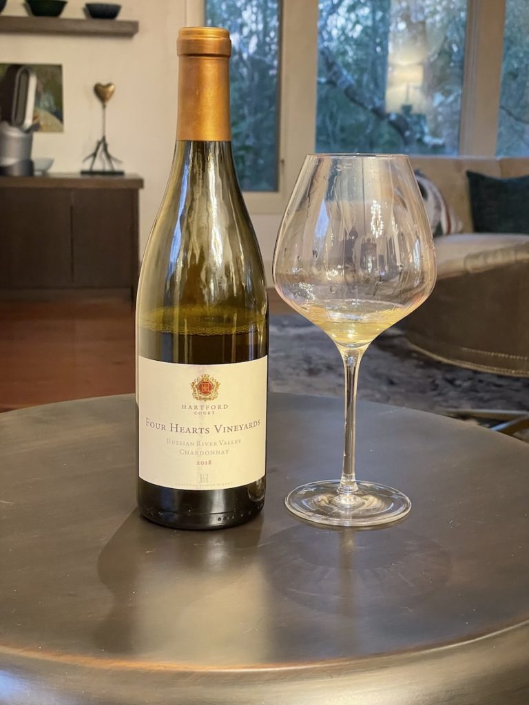 alt="Hartford Court 2019 Chardonnay Four Hearts Vineyard bottle and glass"