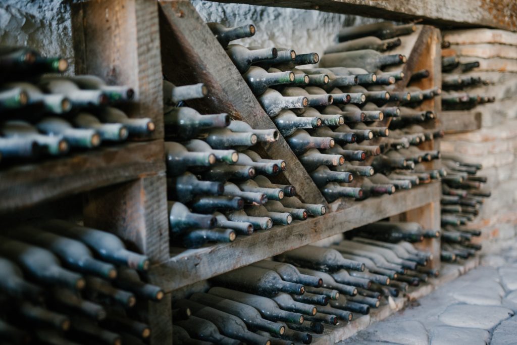 alt="old wine bottles in cellar"