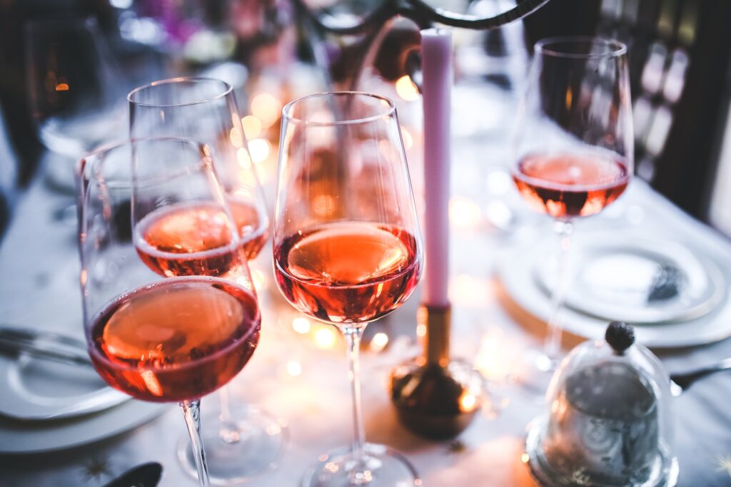 Glasses of Rosé wines on dinner table with white table cloth plates and silverware